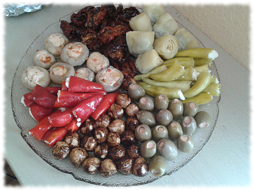 Vorspeisenplatte mit gefllten Peperoni rot und grn, gefllten grnen Oliven, gefllten Champignons, Artischocken und selbst eingelegten Mozzarellakgelchen und getrocknete Tomaten.