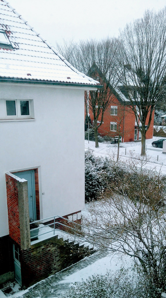 Wohngebiet mit dnner Schneedecke, aufgenommen aus dem Fenster. 
