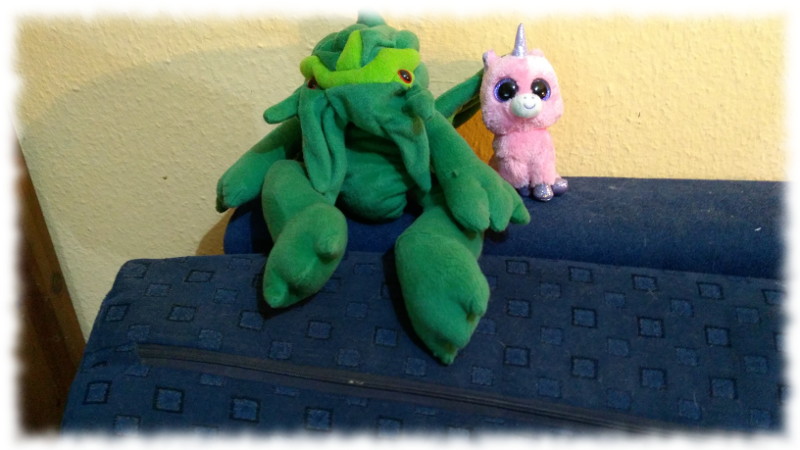 Rosa Plscheinhorn und Cthulhu-Plschhandpuppe auf Sofalehne