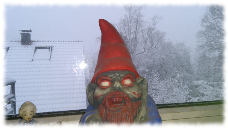 Verschneiter Garten, im Vordergrund Fensterbank mit Zombiegartenzwerg.
