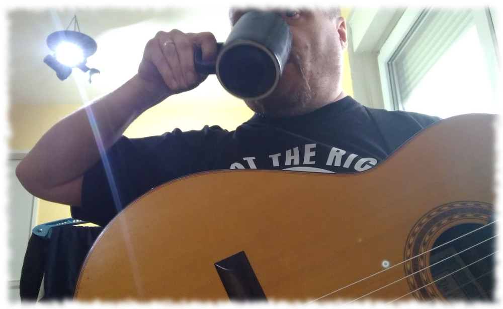 Ulf trinkt Tee mit Gitarre auf dem Scho.