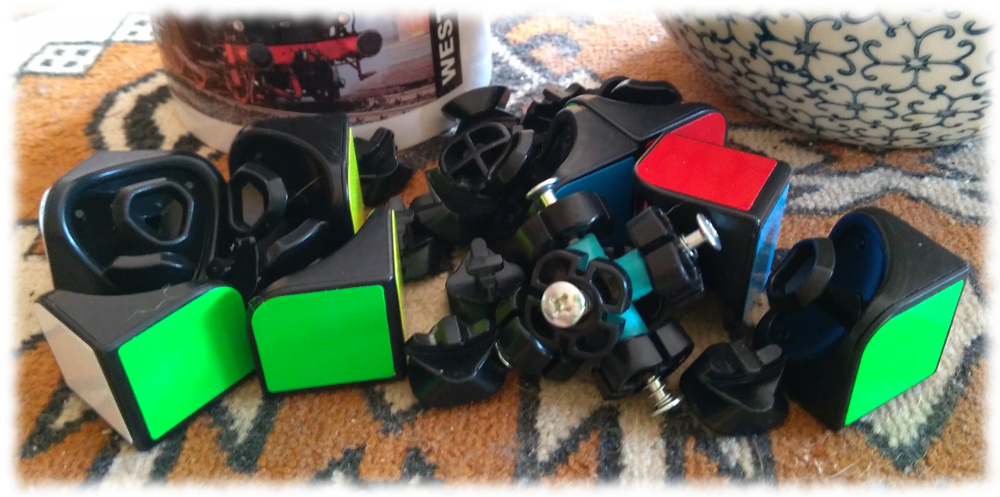 Die Trmmer des kleinen Rubik-Wrfels vor meinem Teegeschirr. Ziemlich viele Teile.