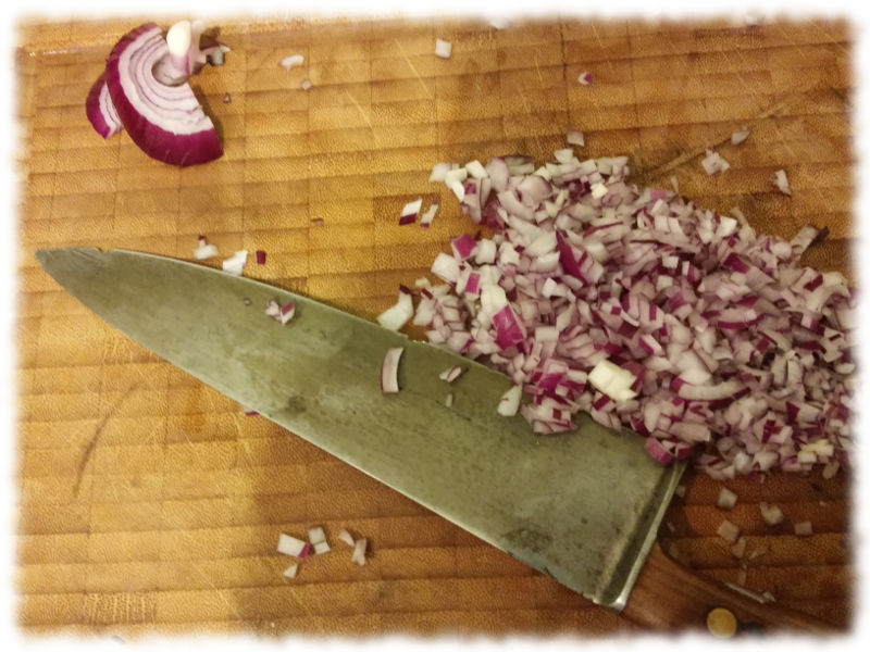 Zwiebelwrfel mit Kochmesser