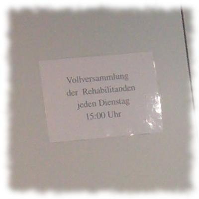 Schild: Vollversammlung der Rehabilitanden jeden Dienstag um 15:00 Uhr.